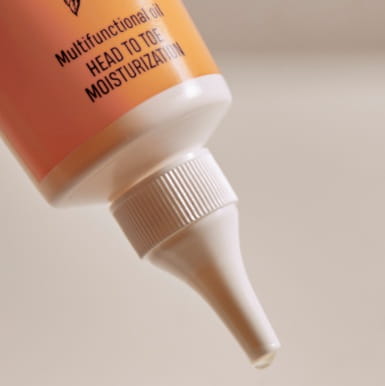 Zbliżenie na precyzyjny aplikator tubki Nurme 100% Pure Shea Oil – kryształowa kropla oleju shea spływa z białej końcówki dozującej..jpg