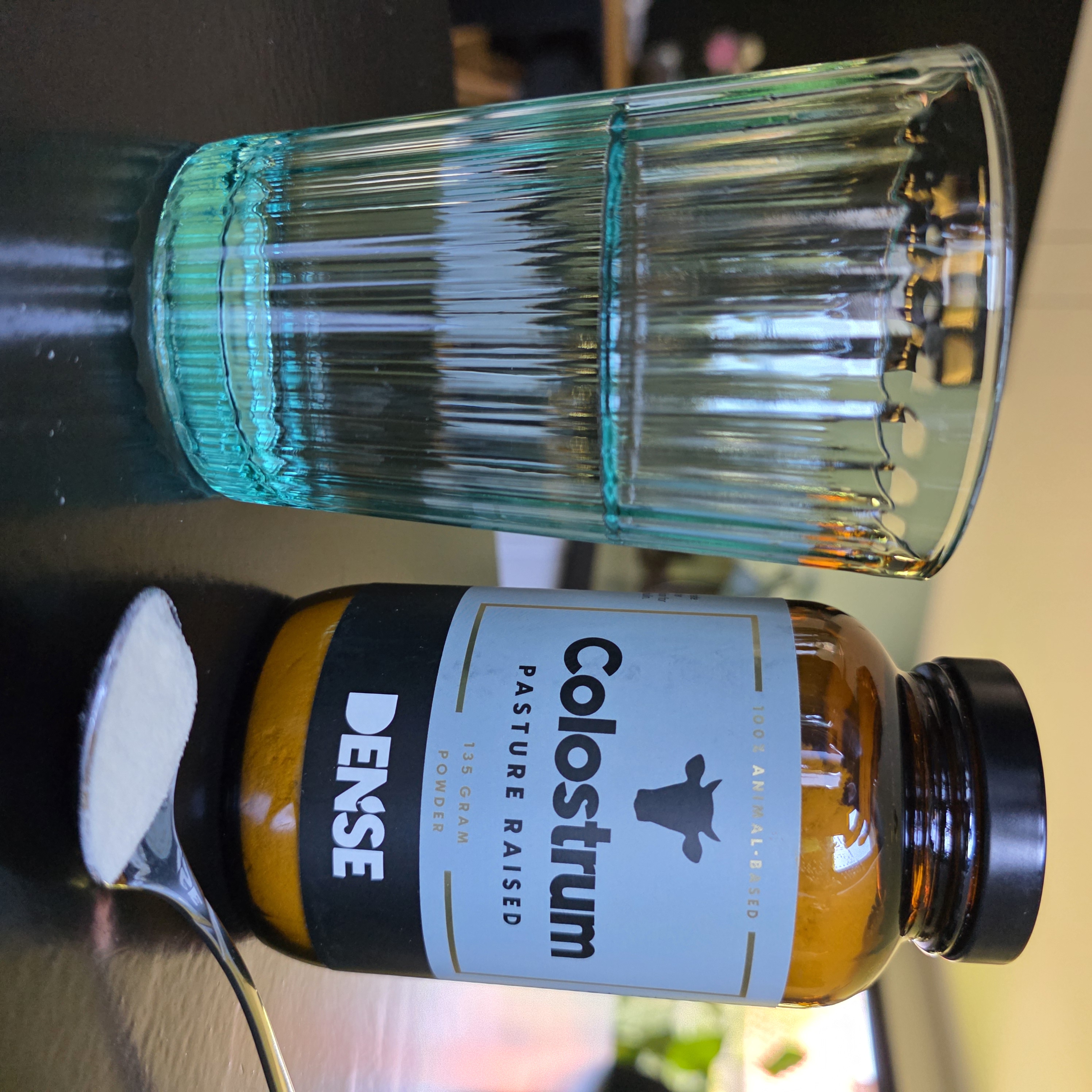  Dense Colostrum proszek na łyżce ze szklanką wody — sposób stosowania